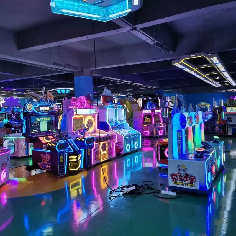 Technician troubleshooting a commercial claw machine in an arcade